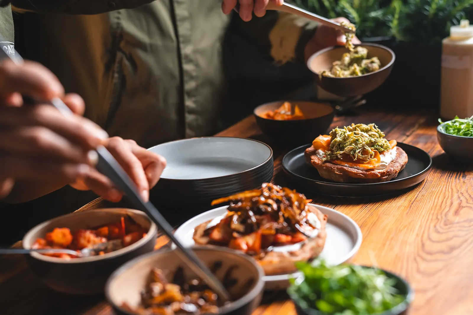 Prostřený stůl plný langošů, kimchi a příloh